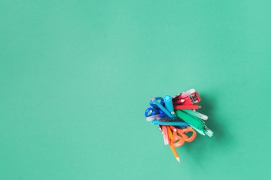 Camdan bir dairede çeşitli ofis ve okul kırtasiyeleri yeşil renkte yatıyordu.