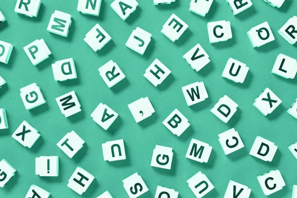 Scattered letter cubes on monochrome green background — Stock Photo, Image