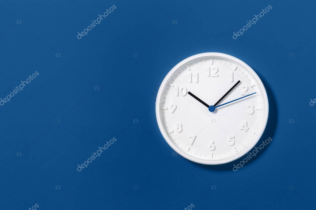 big white wall clock on blue background