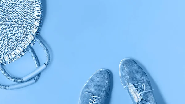 Niebieskie buty i słomkowa torba na monochromatycznym tle — Zdjęcie stockowe