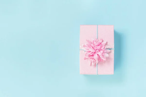 Un coffret cadeau rose avec fleur sur bleu pastel — Photo