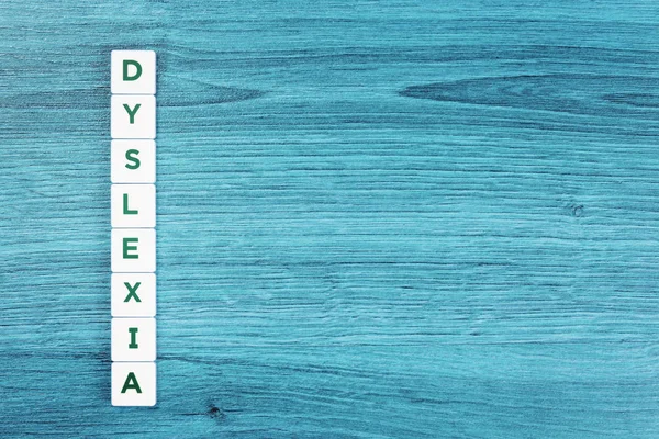 Dyslexia έννοια, λέξη στο μπλε γραφείο — Φωτογραφία Αρχείου