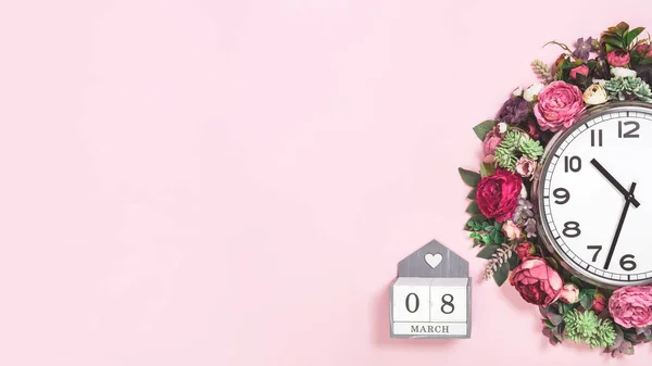 Part of wall clock in blooming flowers on candy pink background — Stock Photo, Image