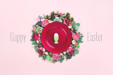 Büyük kırmızı bir tabakta yeşil bir Paskalya yumurtası. Üzerinde bol güller ve ince renklerde şakayık çiçekleri vardı. Paskalya bayramı kartı konseptin kutlu olsun. Boşluğu kopyala