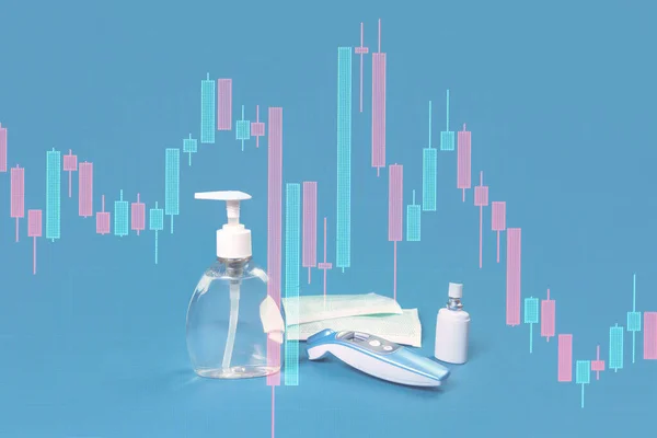 Stock market graph crash and hand sanitizer, flu mask, antibacterial soap and thermal scanner on blue. Personal hygiene and disinfection during viral pandemic and flu season financial crisis markets response
