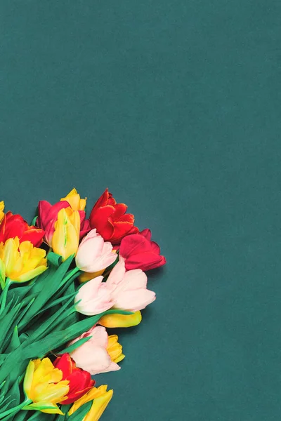 Fresh tulips bouquet on teal background