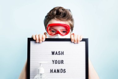 Maskeli çocuk ellerini yıka yazısını antibakteriyel sabunla imzala. Salgın ve grip mevsimi posterleri sırasında virüs ve koronavirüs mikroplarına karşı kişisel temizlik ve dezenfeksiyon