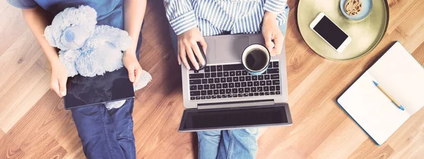 Uzaktan kumanda için dizüstü bilgisayarı ve tableti olan ya da yerde oturan not defteri ve aperatiflerle ders çalışan kadın anne ve çocuk. Mesafe öğrenme veya serbest çalışma afişi veya izolasyon yaşam tarzı