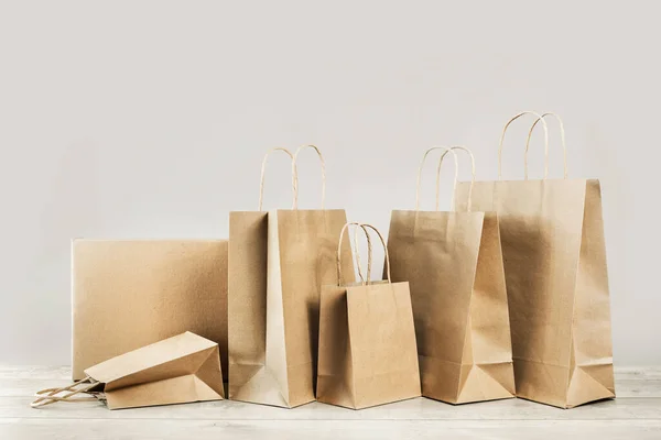 Çeşit çeşit kağıt çantaları ve kutuları gri renkte taşır. Mal ve bakkal teslimatı, alışveriş kuryesi. Çevre ve çevre dostu ambalaj, plastik ücretsiz paket