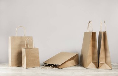 Çeşit çeşit kağıt çantaları ve kutuları gri renkte taşır. Mal ve bakkal teslimatı, alışveriş kuryesi. Çevre ve çevre dostu ambalaj, plastik ücretsiz paket