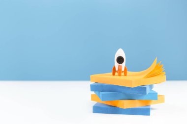 İş ya da eğitim gelişimi ve başarı konsepti afişi. Roket ve dizüstü bilgisayar beyaz ofiste ya da mavi arka planı olan ev masasında. Yenilikçi bir düşünce. Boşluğu kopyala