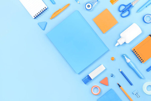Ассорти офиса и школы белый оранжевый и синий канцтовары на пастельном фоне в качестве угла границы. Квартира лежала с копировальным пространством для возвращения в школу или образования и ремесленной концепции. Синий монохромный баннер
