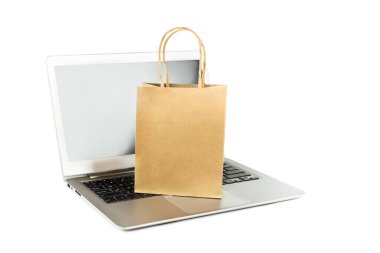 Laptop ve kağıt alışveriş çantası izole edildi. Paketler çevrimiçi siparişler