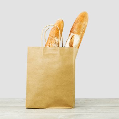 Tahtadaki kağıt torbada iki Fransız ekmeği.