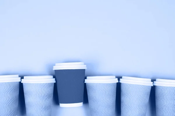 Paper cups on blue background Royalty Free Stock Photos