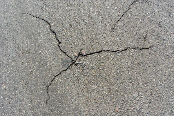 Silniční jáma a praskliny na asfaltu close-up makro. Pozadí te Stock Snímky