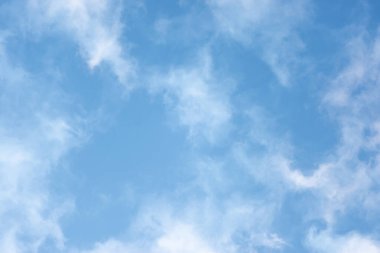 Bulutlar ve güneş ışınlarıyla parlayan parlak gökyüzü.