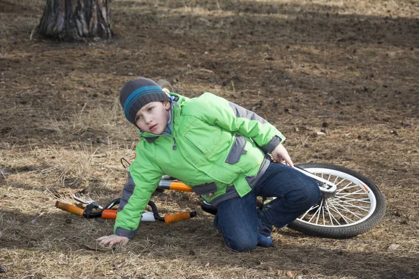 Primavera na floresta menino caiu de sua bicicleta . — Fotografia de Stock