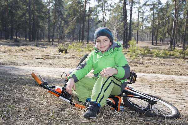 Szczęśliwe dziecko zabawny mały chłopiec siedzi z jego rower w f sosna — Zdjęcie stockowe