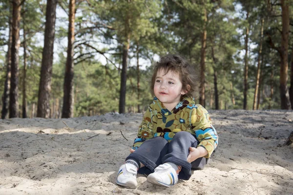 In the summer of funny little girl sitting on the ground in a pi — Stock Photo, Image