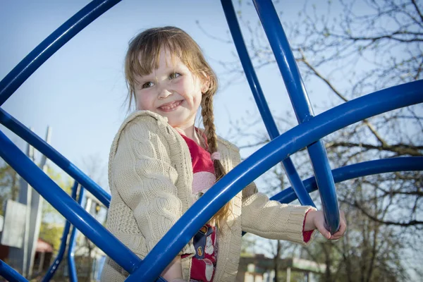 In het voorjaar van de speeltuin is een lachende meisje. — Stockfoto