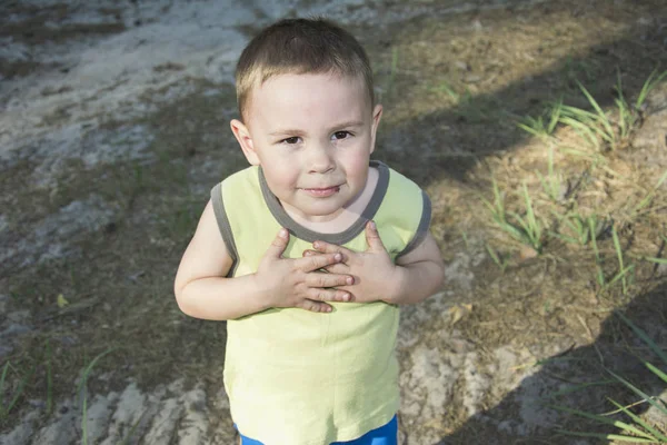 In the summer on the street the boy folded his arms on his chest — Stock Photo, Image