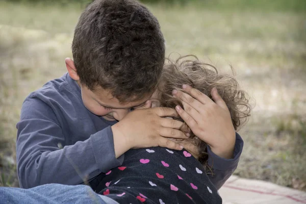 In the summer in the forest, the elder brother comforts his litt — Stock Photo, Image