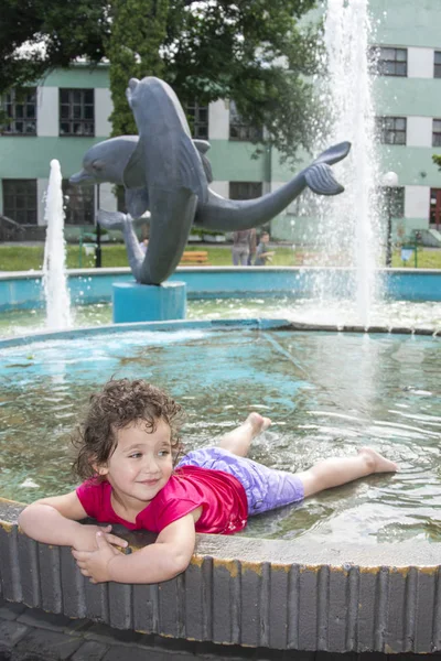 In de zomer, gir spelen in de fontein in het park. — Stockfoto