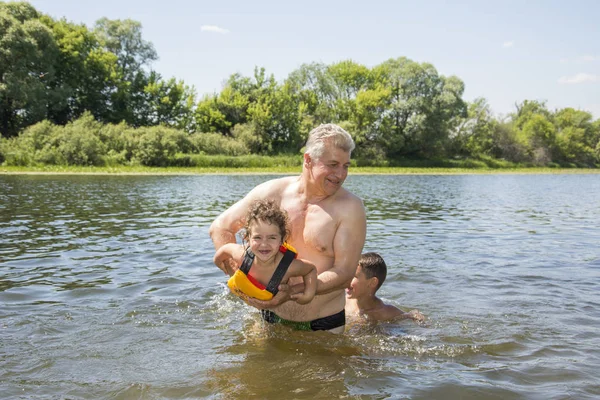In estate, in una giornata luminosa e soleggiata sul fiume, il nonno — Foto Stock