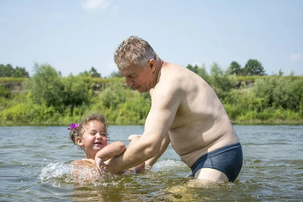 In summer, on a bright, sunny day on the river, grandfather teac — Stock Photo, Image