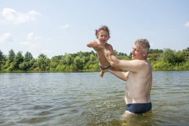 Nehri üzerinde parlak, güneşli bir günde yaz aylarında teac büyükbaba