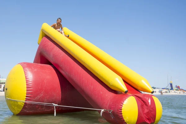 No verão, em um dia ensolarado no mar, o menino sai em um inflat — Fotografia de Stock