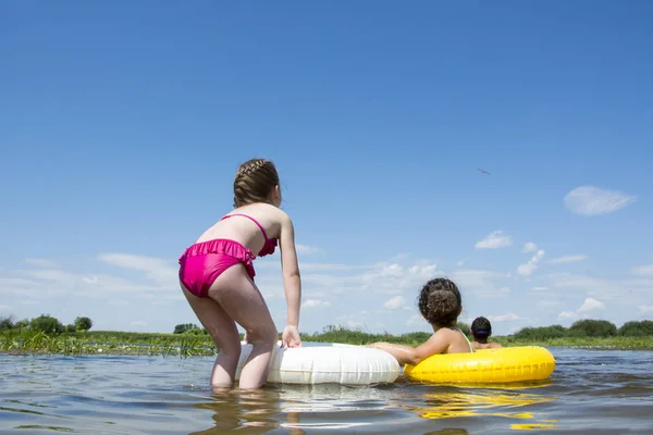 In summer, on a bright, sunny day, children swim in inflatable c — Stock Photo, Image