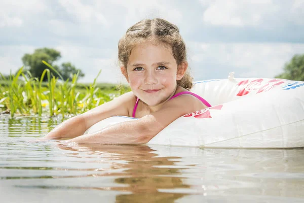 Im Sommer schwimmt ein Mädchen an einem hellen, sonnigen Tag auf dem Fluss — Stockfoto