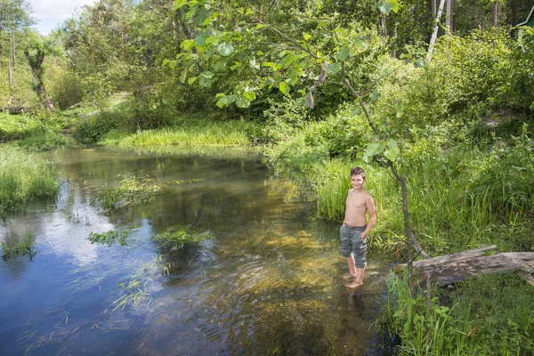 En verano hay un niño en la orilla del río. . — Foto de Stock