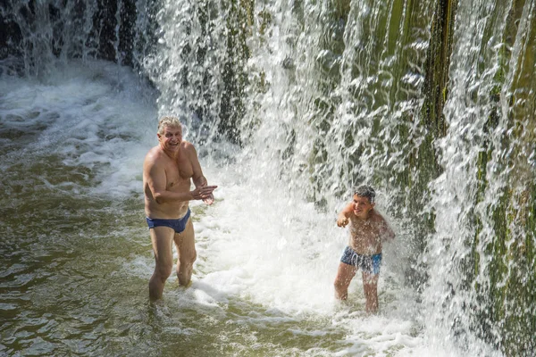 Waterfall. In the summer on the dam people swim under the stream — Stock Photo, Image
