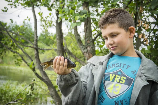 In de zomer op een visserij jongetje gevangen een grote karper. — Stockfoto