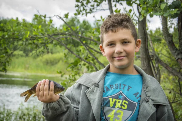 En el verano en un niño pescador atrapado una gran carpa . —  Fotos de Stock