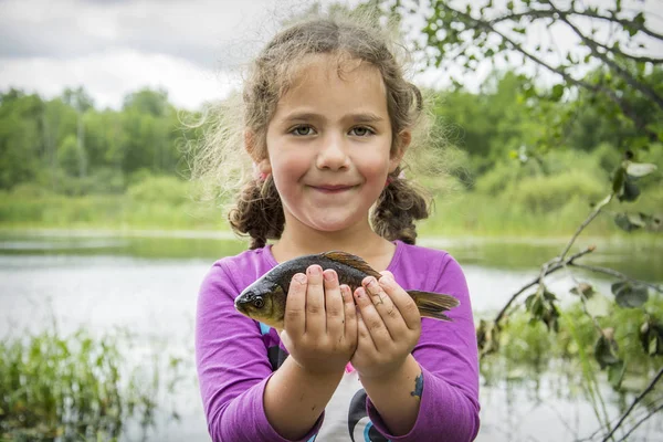 In the summer on a fishing little girl caught a large carp. — Stock Photo, Image