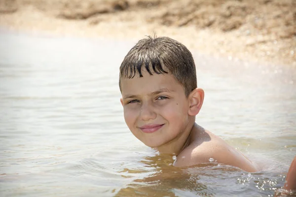 In summer, a boy is swimming on the sea. Close-up. — Stock Photo, Image