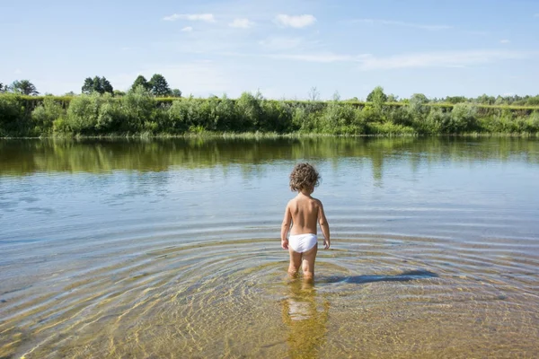 水に川の夏に小さな女の子が立っています。. — ストック写真