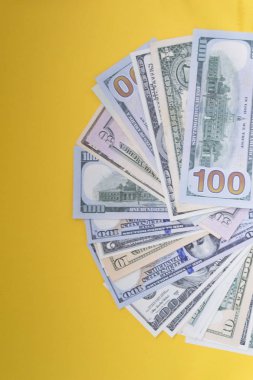 Abd Doları: Çeşitli Amerikan doları banknotlarının dağınık hayranı renkli arka planda iş kavramının en iyi görünümü.