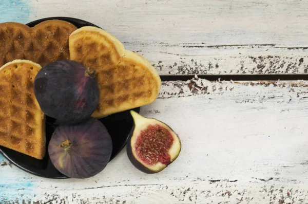 Figs on a plate with heart-shaped cookies. White wooden background. Autumn concept. — Stock Photo, Image