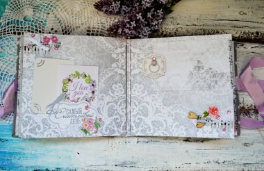 El yapımı fotoğraf albümü koleksiyonu. Diy. Albüm yapmak, kağıt kesmek, kesim yapmak, kesim yapmak, kağıt çiçekler, kurdeleler ve kabartma için malzemelerle dolu bir masa. Kadın hobisi. Düğün albümü. El işi kavramı..