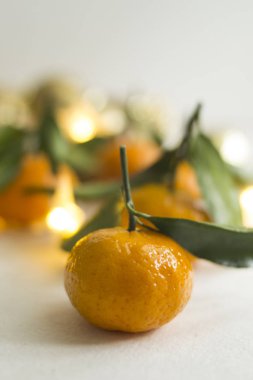 Bulanık mandalina ve altın topların arka planında turuncu mandalina. Işıltılı çelenklerle donuk, gümüşi bir arka planda kış kompozisyonu. Turuncu turunçgil meyvesi ve makro shot bırakır.