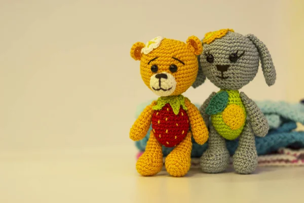 Perro de juguete de punto gris y un oso amarillo - en ropa de punto de color - juguete amigurumi de color sobre un fondo claro. Copiar espacio. concepto de costura . —  Fotos de Stock