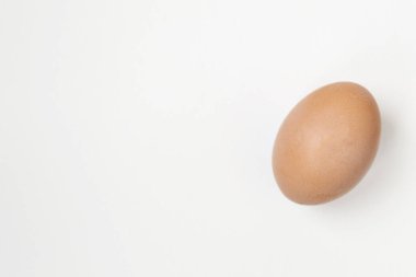 Beyaz arka planda yatan bir yumurtaya yaklaş. Mesajlaşmak için bir yer var. Paskalya konsepti, yiyecek.