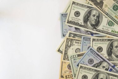 Farklı dolar küperlerinin yan çerçeveleri beyaz arka planda gelişigüzel uzanır. Kavram işi, parasal fon. Metin için bir yer var.