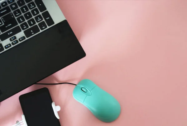 Desk office desk top view. Remote work or training. Workspace table with office accessories, including laptop computer with mouse, mobile phone on a pink background. Copy space for text. Flat lay