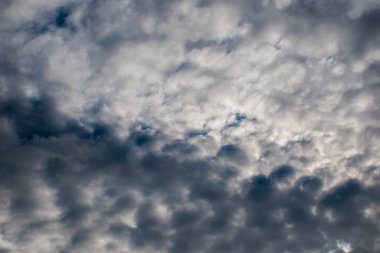 Mavi gökyüzünde, arkaplanda, karmakarışık gri bulutlar